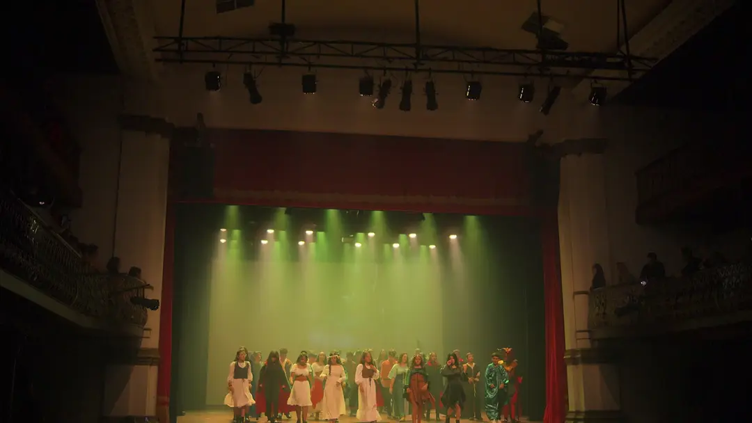O teatro inteiro com o elenco reunido no palco
